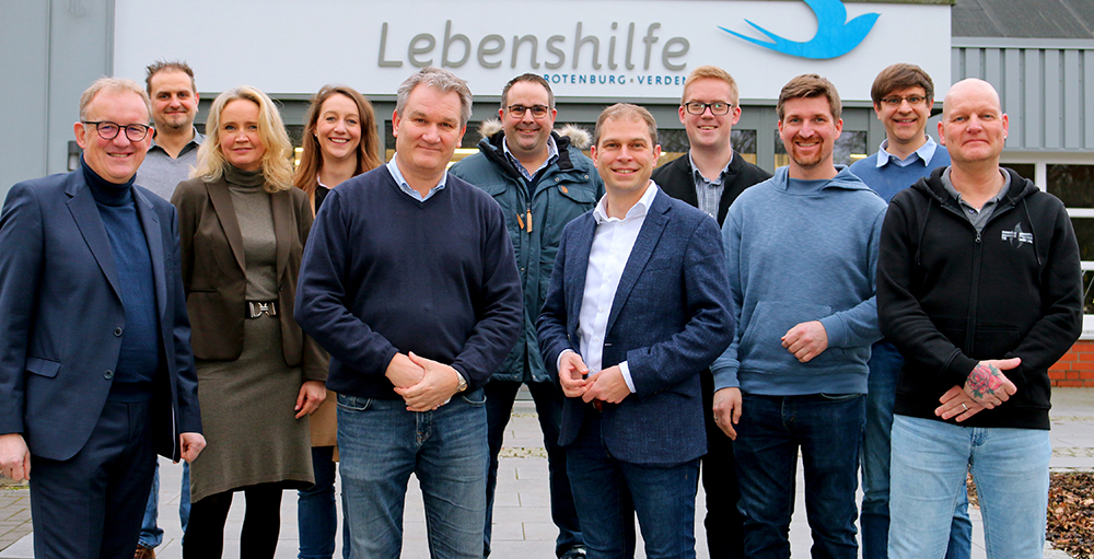 Gäste und Gastgeber beim Gruppenfoto im Außenbereich der Lebenshilfe Rotenburg-Verden.